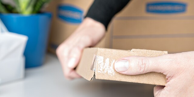 Ausbessern der Ecken von Aufbewahrungsboxen mit Scotch® Super-Hold Klebeband
