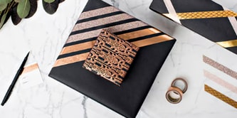 Geschenke kombinieren, indem ein kleineres Geschenk mit Scotch® doppelseitigem Klebeband an ein größeres befestigt wird
